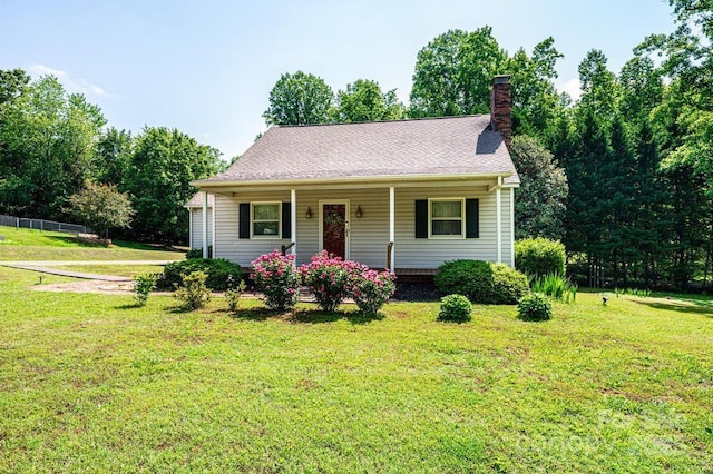 view of front facade featuring a chimney, a front lawn, and covered porch