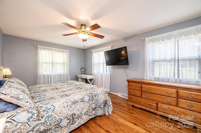 bedroom with wood finished floors, a ceiling fan, and baseboards
