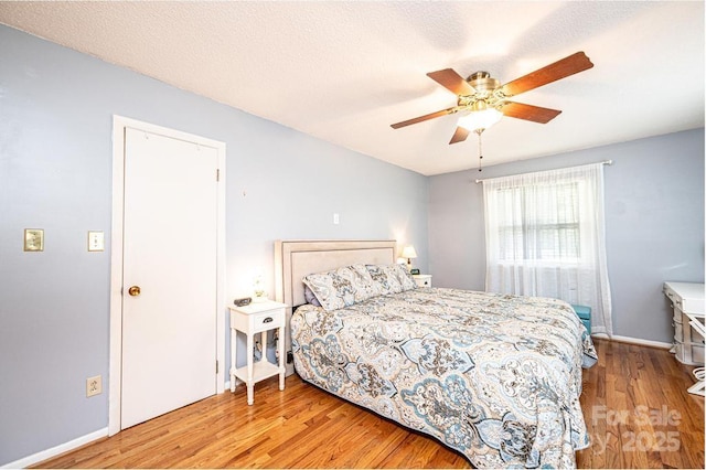 bedroom with wood finished floors, baseboards, and ceiling fan