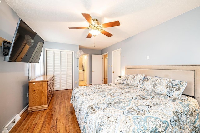 bedroom featuring light wood-style flooring, baseboards, ceiling fan, and ensuite bathroom