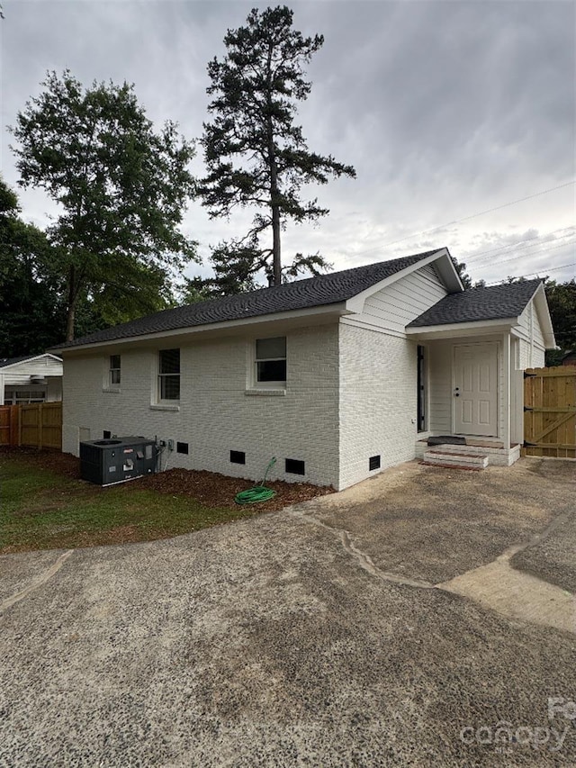 3700 Denson Pl, Charlotte, NC 28215 - back of house featuring crawl space, brick siding, central AC, and a shingled roof