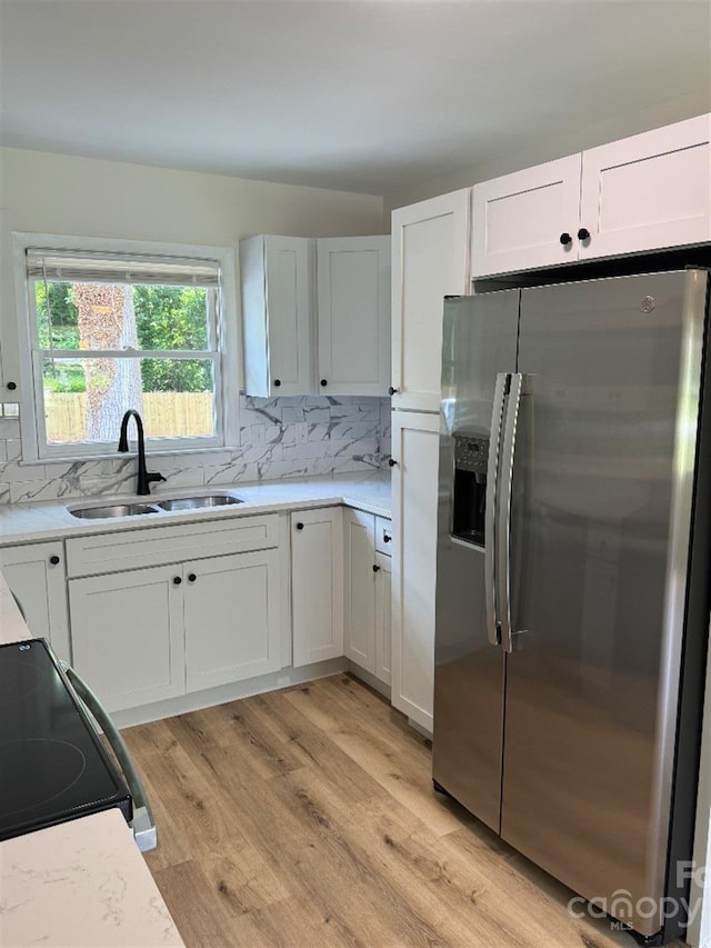 3700 Denson Pl, Charlotte, NC 28215 - kitchen featuring stainless steel fridge with ice dispenser, a sink, light wood-type flooring, and tasteful backsplash