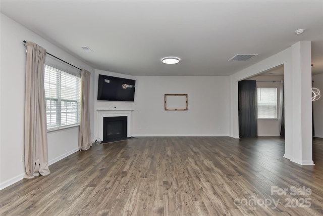 9505 Cotswood Pl, Gastonia, NC 28056 - unfurnished living room with wood finished floors, a fireplace with flush hearth, and healthy amount of natural light