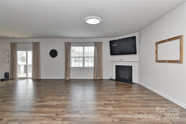 9505 Cotswood Pl, Gastonia, NC 28056 - unfurnished living room featuring a fireplace, healthy amount of natural light, and wood finished floors