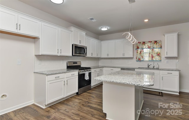 9505 Cotswood Pl, Gastonia, NC 28056 - kitchen with stainless steel appliances, white cabinets, decorative backsplash, dark wood-style floors, and recessed lighting