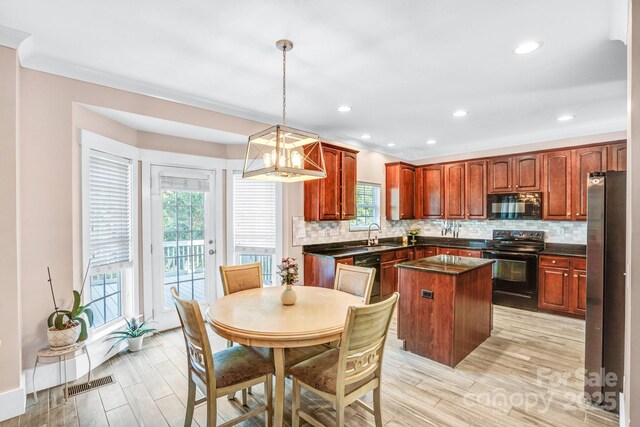 1503 Stoney Ct, York, SC 29745 - kitchen featuring black appliances, dark countertops, a kitchen island, tasteful backsplash, and light wood-type flooring