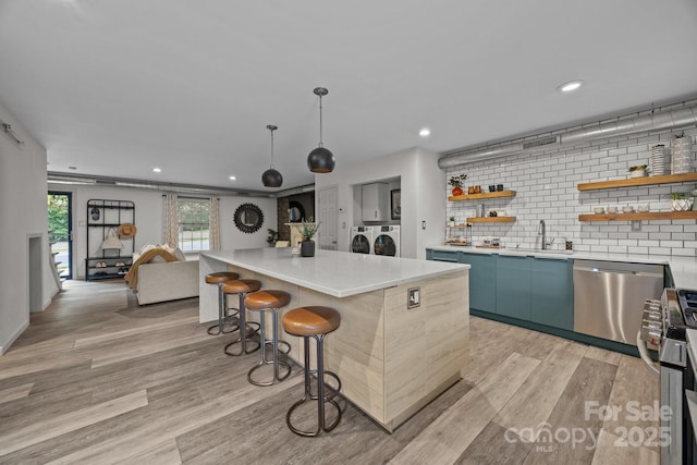 3528 Colony Rd Unit A, Charlotte, NC 28211 - kitchen with stainless steel appliances, a sink, open shelves, washing machine and clothes dryer, and a breakfast bar area