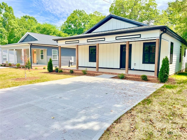view of front of house featuring a porch, board and batten siding, and a front yard