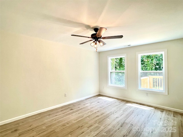 unfurnished room with baseboards, wood finished floors, and a ceiling fan