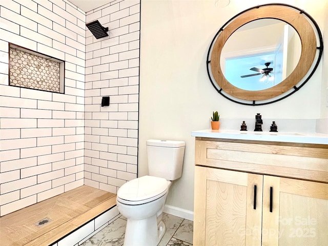 full bath with marble finish flooring, toilet, a stall shower, ceiling fan, and baseboards