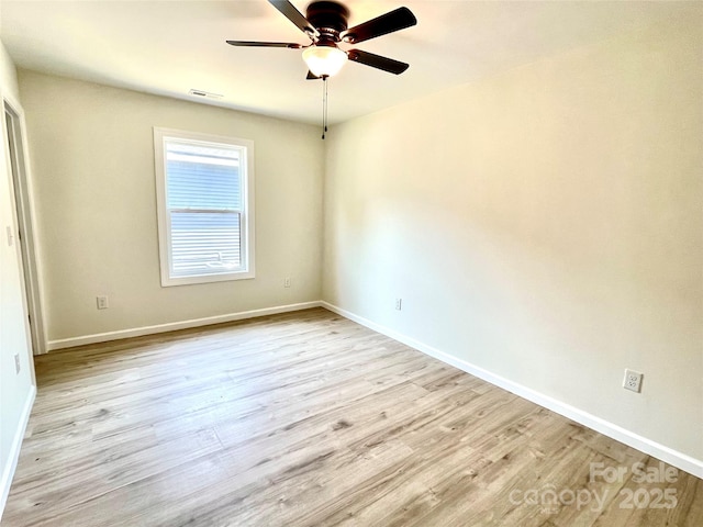 spare room featuring ceiling fan, wood finished floors, and baseboards