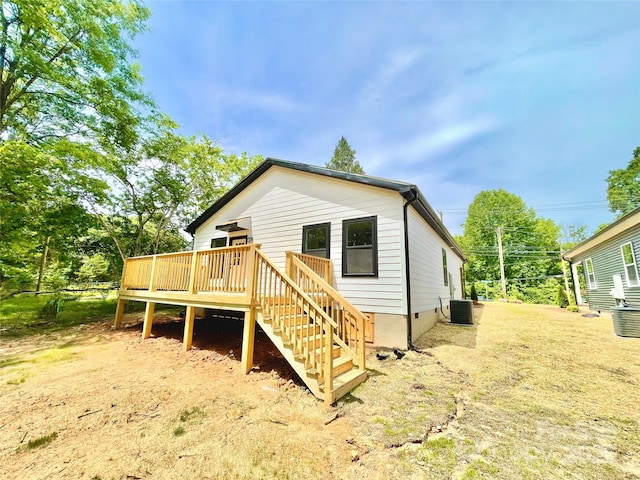 rear view of house with central AC, a wooden deck, and stairs
