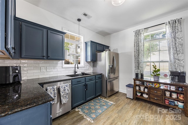 6107 Raisin Tree Ln, Charlotte, NC 28215 - kitchen featuring a sink, appliances with stainless steel finishes, blue cabinets, and light wood-style flooring