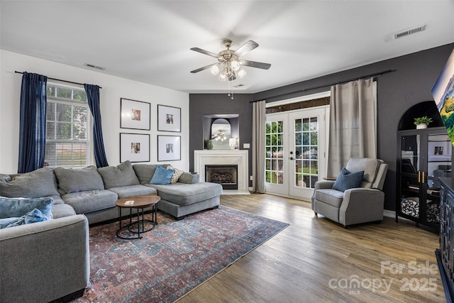6107 Raisin Tree Ln, Charlotte, NC 28215 - living room featuring wood finished floors, a ceiling fan, french doors, and a fireplace with raised hearth