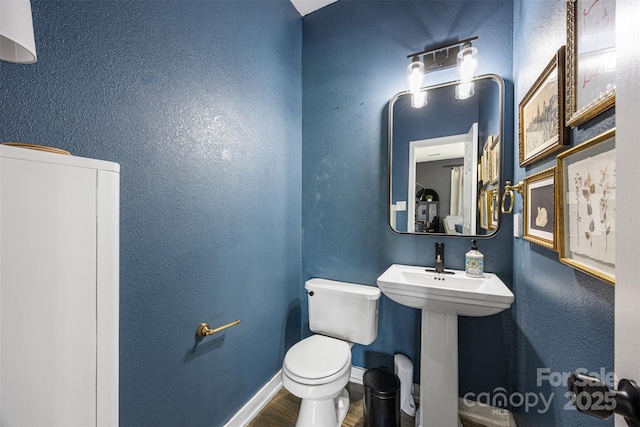 6107 Raisin Tree Ln, Charlotte, NC 28215 - bathroom with toilet, wood finished floors, baseboards, and a sink