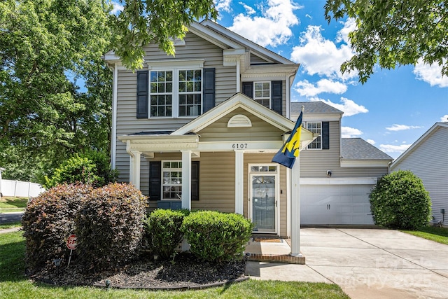 6107 Raisin Tree Ln, Charlotte, NC 28215 - traditional home with concrete driveway, an attached garage, and a porch