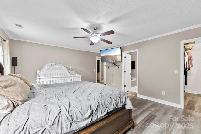 641 Saratoga Dr, Clover, SC 29710 - bedroom featuring a walk in closet, light wood finished floors, a closet, a textured ceiling, and ornamental molding