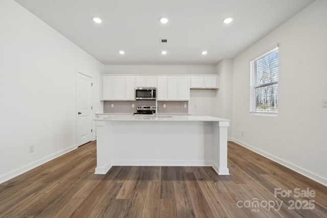 2588 Blue Sky Meadows Dr, Monroe, NC 28110 - kitchen with appliances with stainless steel finishes, a center island with sink, light countertops, white cabinetry, and recessed lighting