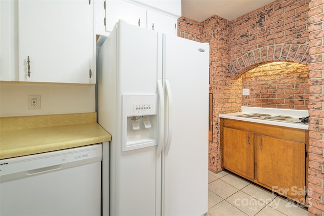 179 Brevard Rd, Asheville, NC 28806 - kitchen featuring white appliances, light countertops, light tile patterned floors, brick wall, and white cabinets