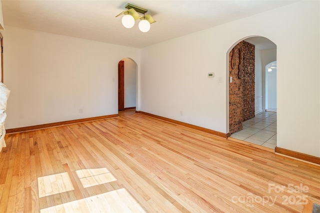 179 Brevard Rd, Asheville, NC 28806 - empty room with arched walkways, light wood-type flooring, and baseboards