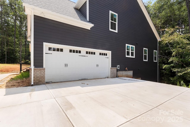 4315 Palm Dr, Denver, NC 28037 - view of side of property with a shingled roof, driveway, and brick siding