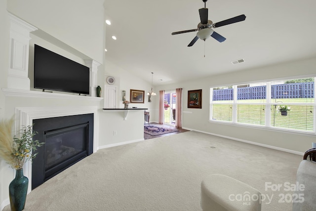 6192 Kilchurn Dr, Fort Mill, SC 29707 - unfurnished living room with carpet, vaulted ceiling, a ceiling fan, and a glass covered fireplace