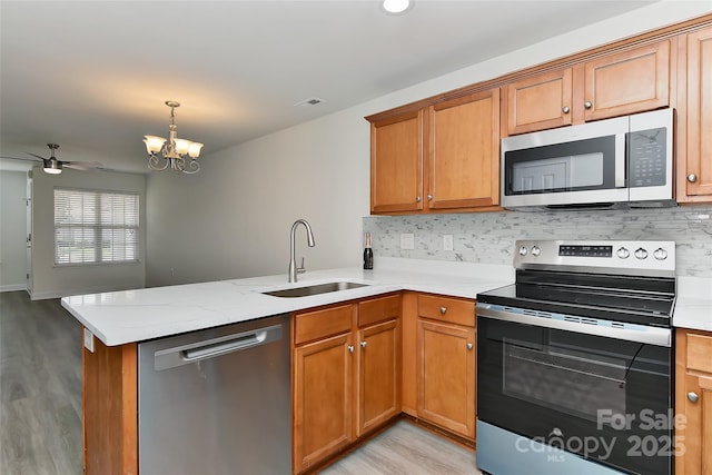 1890 Sandal Brook Rd, Fort Mill, SC 29707 - kitchen with stainless steel appliances, a sink, a peninsula, and light wood-type flooring