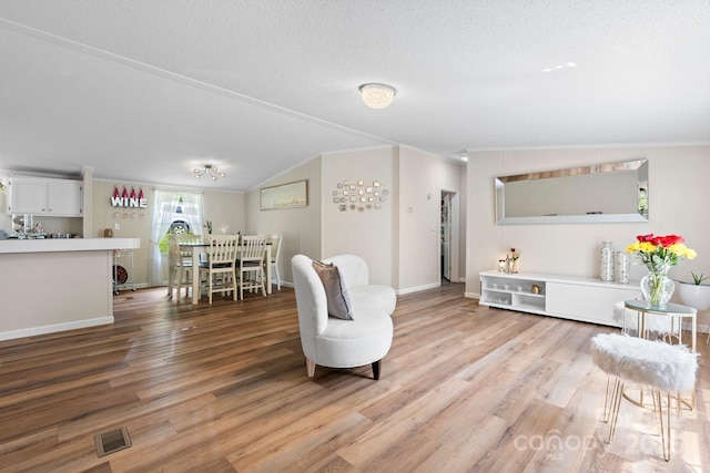 4375 Fox Rd, Lenoir, NC 28645 - living room with light wood-style flooring, lofted ceiling, ornamental molding, a textured ceiling, and baseboards
