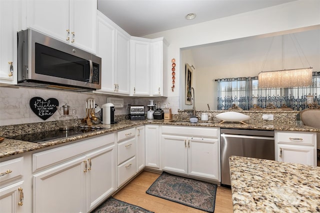 12822 Plumleaf Dr, Charlotte, NC 28213 - kitchen featuring stainless steel appliances, a sink, decorative backsplash, white cabinetry, and light stone counters