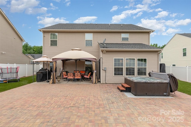 12822 Plumleaf Dr, Charlotte, NC 28213 - back of house with a hot tub, a gazebo, a patio, a trampoline, and a fenced backyard