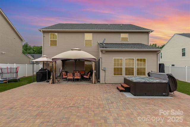 12822 Plumleaf Dr, Charlotte, NC 28213 - rear view of house with a hot tub, a gazebo, a patio area, a trampoline, and a fenced backyard