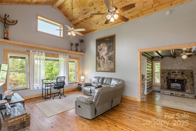 223 Smith Cove Rd, Candler, NC 28715 - living area featuring a ceiling fan, a wood stove, wood ceiling with exposed beams, hardwood / wood-style flooring, and high vaulted ceiling