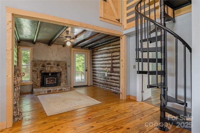 223 Smith Cove Rd, Candler, NC 28715 - unfurnished living room featuring hardwood / wood-style floors, healthy amount of natural light, stairs, a ceiling fan, and beam ceiling