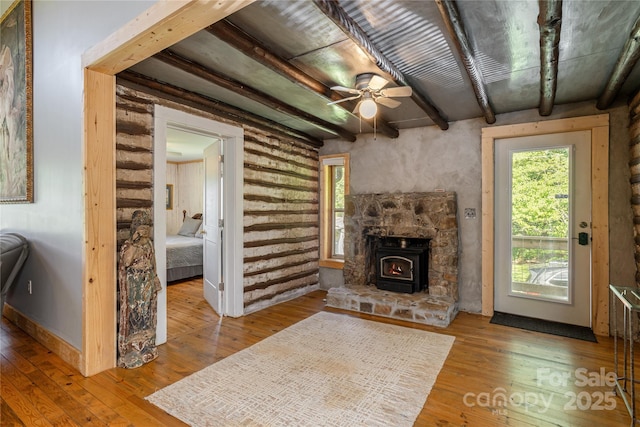 223 Smith Cove Rd, Candler, NC 28715 - living area with plenty of natural light, beamed ceiling, ceiling fan, hardwood / wood-style floors, and a wood stove