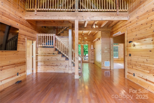 148 Pearl Way, Burnsville, NC 28714 - staircase with wood walls, wood finished floors, wood ceiling with exposed beams, and a towering ceiling