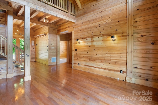 148 Pearl Way, Burnsville, NC 28714 - spare room with wooden walls, wood-type flooring, stairway, and wood ceiling with exposed beams