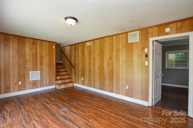 923 Yuma St, Charlotte, NC 28213 - unfurnished room featuring wood finished floors, wooden walls, stairway, a textured ceiling, and baseboards