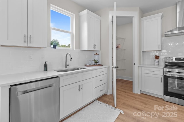 4949 Rimer Rd Unit 4, Concord, NC 28025 - kitchen with stainless steel appliances, a sink, wall chimney range hood, white cabinets, and tasteful backsplash