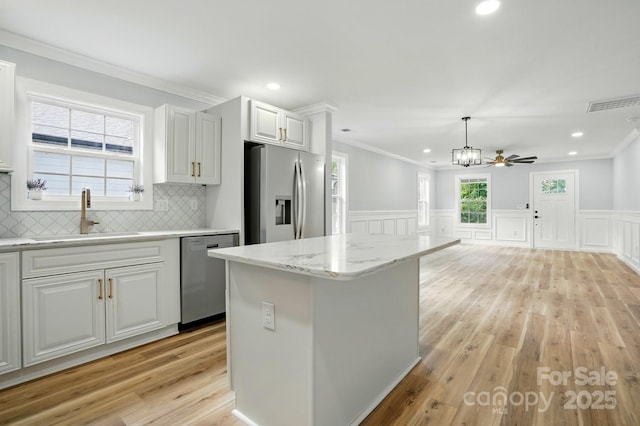 251 Hall Ave NW, Concord, NC 28027 - kitchen with appliances with stainless steel finishes, a sink, light wood-style flooring, crown molding, and white cabinets