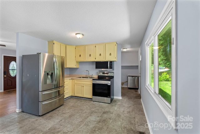 1075 Parkview Dr, Gastonia, NC 28054 - kitchen featuring appliances with stainless steel finishes, cream cabinetry, baseboards, light countertops, and a sink