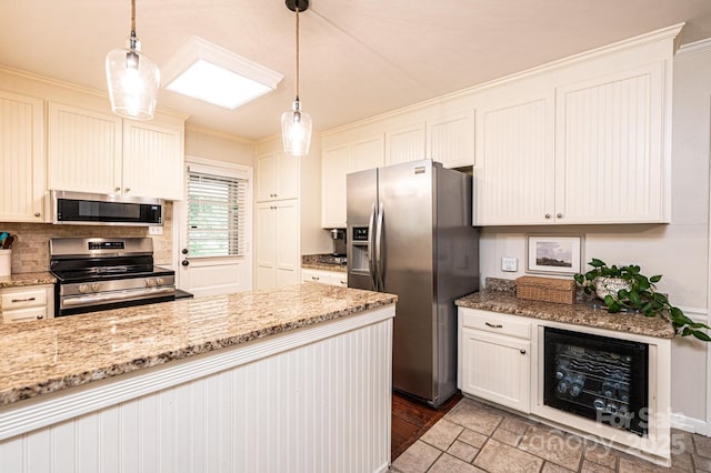 kitchen featuring stainless steel appliances, wine cooler, crown molding, decorative light fixtures, and light stone counters
