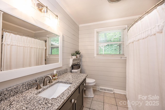 bathroom featuring ornamental molding, healthy amount of natural light, tile patterned floors, vanity, and toilet
