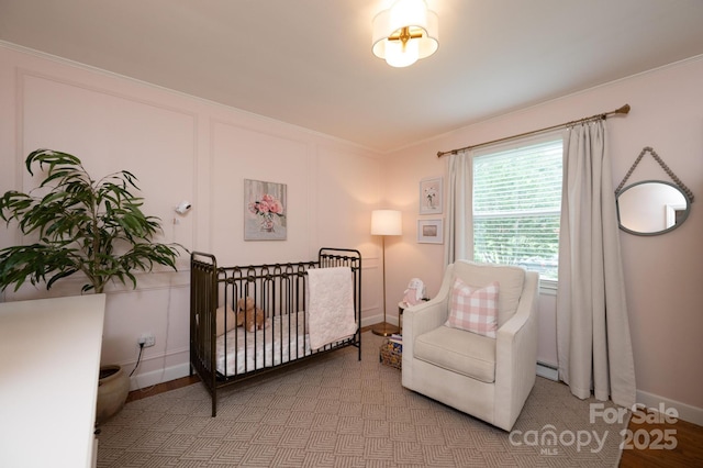 bedroom with ornamental molding, baseboards, and a baseboard radiator