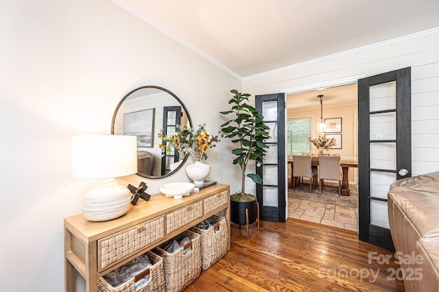 hall featuring wood finished floors and crown molding