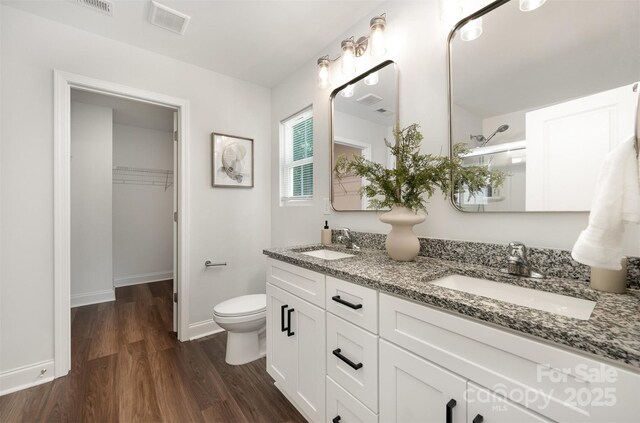 3004 Marlowe Ave, Charlotte, NC 28208 - bathroom with double vanity, wood finished floors, an enclosed shower, toilet, and baseboards