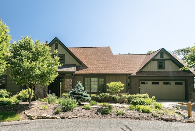 craftsman inspired home with a garage, a shingled roof, board and batten siding, driveway, and stone siding