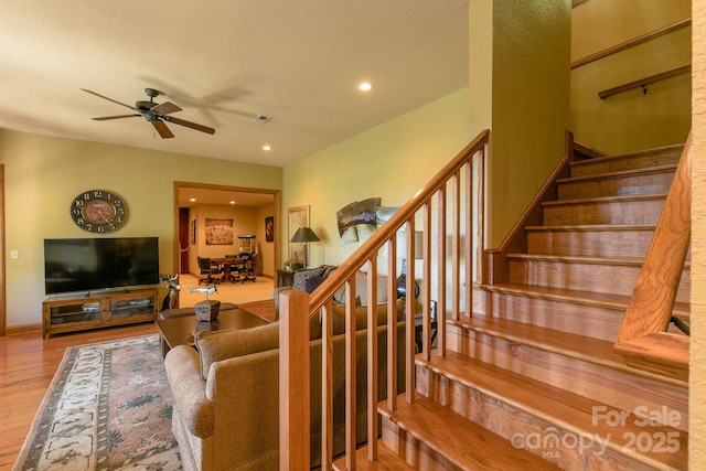 living room featuring wood finished floors, a ceiling fan, stairs, recessed lighting, and baseboards