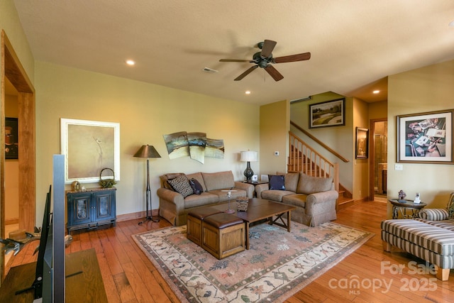 living room featuring wood-type flooring, ceiling fan, stairway, baseboards, and recessed lighting