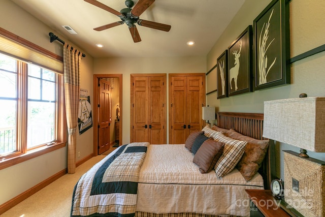 bedroom with light colored carpet, baseboards, recessed lighting, two closets, and ceiling fan