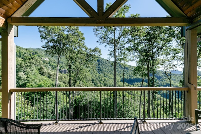 deck featuring a forest view and a mountain view